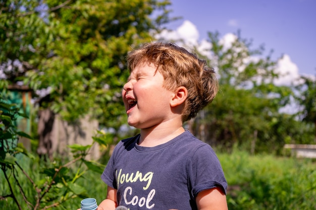 Little four years boy blow soap bubbles, outdoors, summer, happy boy