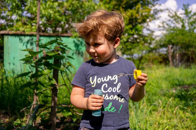 Little four years boy blow soap bubbles, outdoors, summer, happy boy