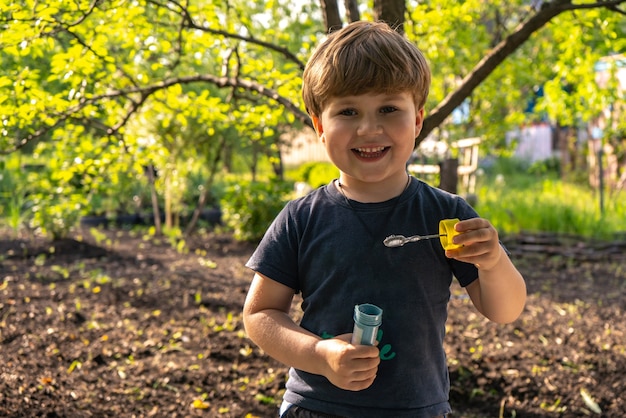 Little four years boy blow soap bubbles, outdoors, summer, happy boy