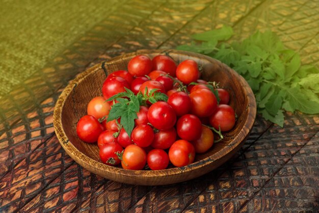 Little fresh tomatoes in a bowl Cherry tomatoes in bowl on rustic table