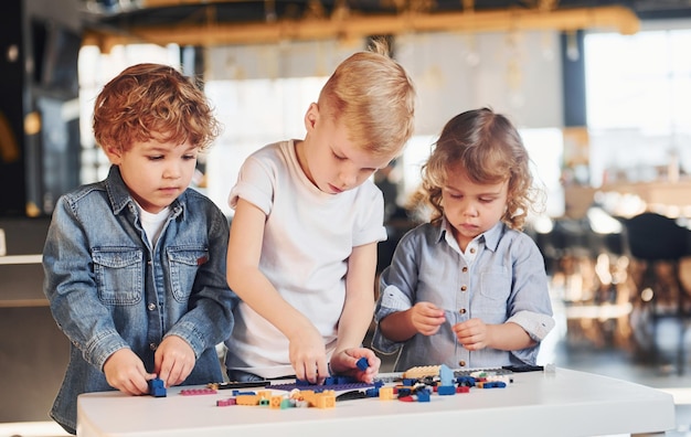 Little friends have fun with construction toys in playroom Kindergarten educational games