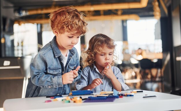 Little friends have fun with construction toys in playroom Kindergarten educational games