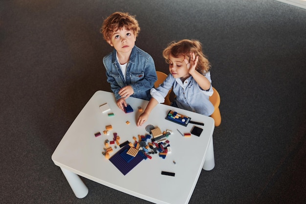 Маленькие друзья веселятся со строительными игрушками в игровой комнате Детские развивающие игры