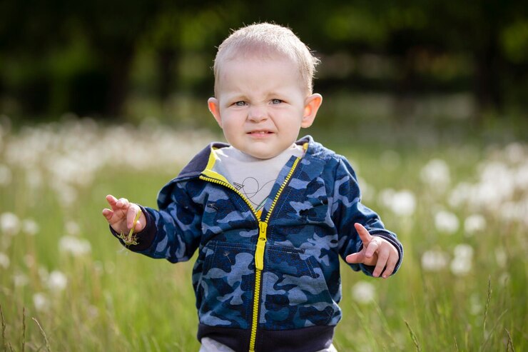 Little funny boy outdoors looking at the camera