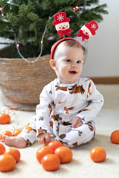 Little funny boy sitting near new year eve