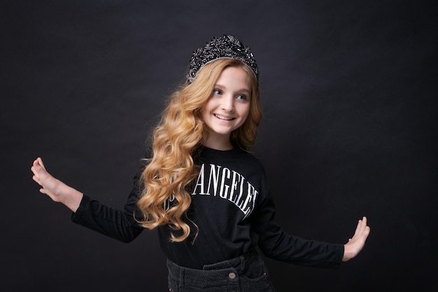 Little funny cute birthday girl princess years old wears dark clothes with a crown tiara on a black