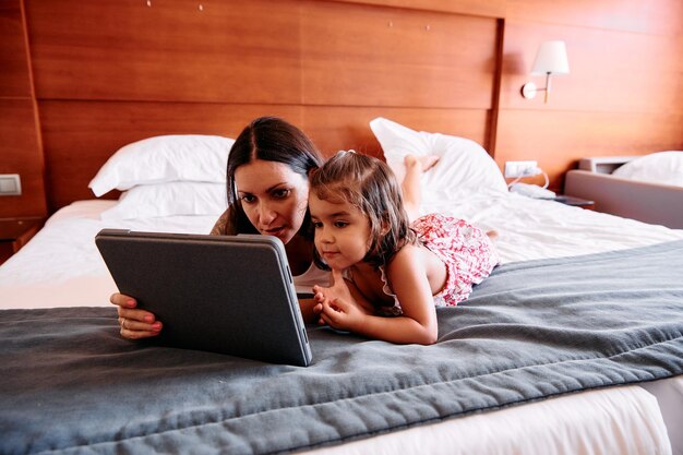 사진 호텔 방에서 ipad를 사용하는 어린 소녀와 그녀의 어머니