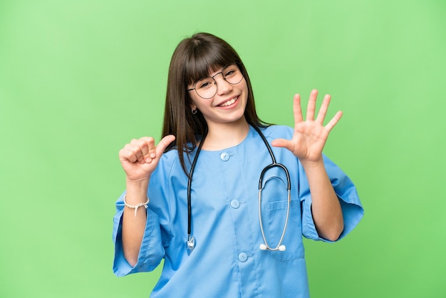 손가락으로 6을 세는 격리된 크로마 키 배경 위에 외과 의사인 어린 소녀