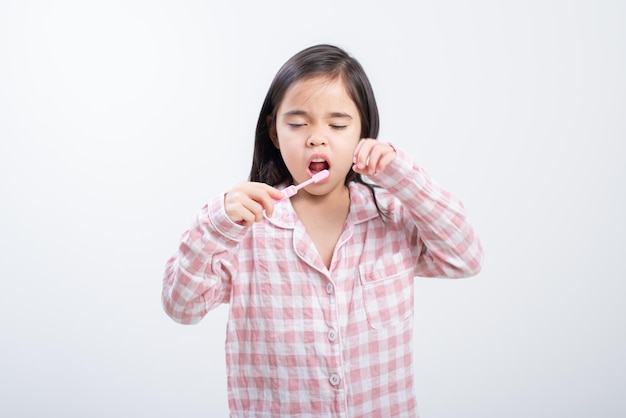 Little girl Asia brushing teeth happily white background