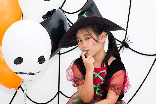 Little girl asian in witch costume