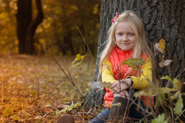 Little girl in the autumn forest