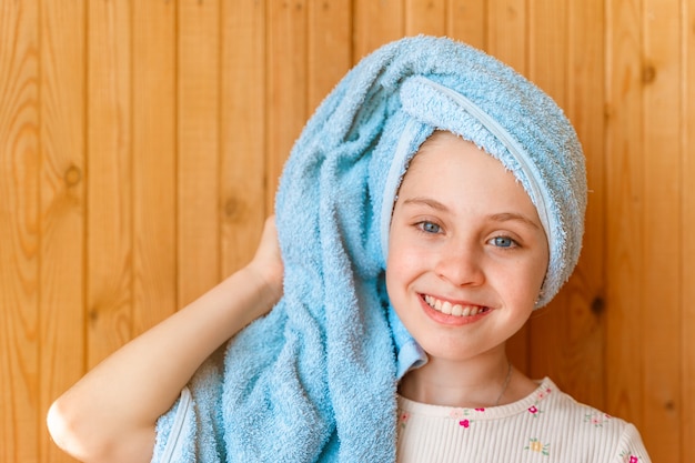 Photo little girl baby after shower with wet hair wrapped in towel