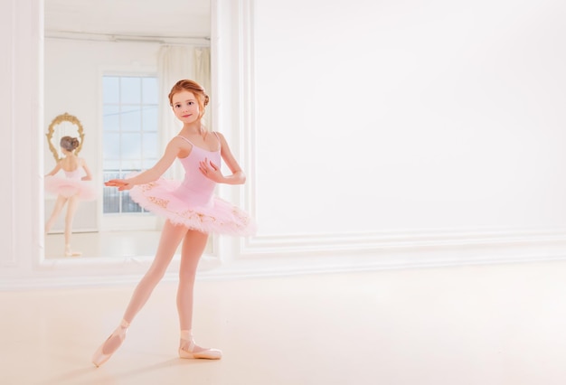 Photo little girl ballerina dancer in tutu dress learning ballet dance at dance school