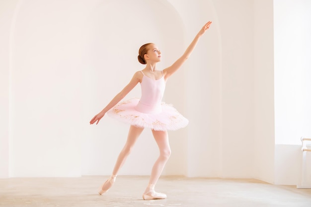 Una bambina ballerina sta ballando sul palco in tutù su scarpe da punta con  un tamburello, una variazione classica di esmeralda.