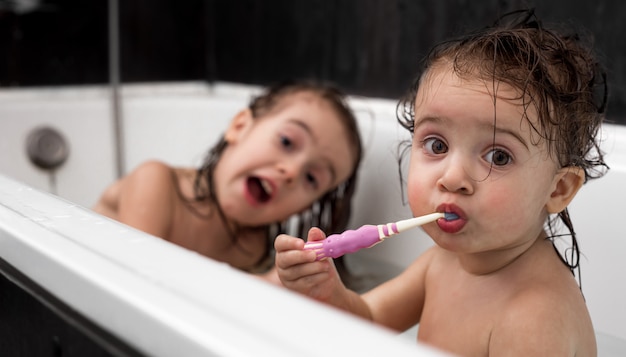 Photo little girl bathes and brushes her teeth in the bathroom