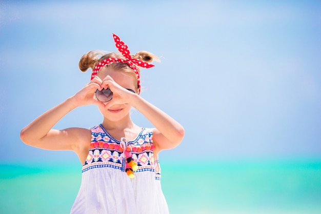 Little girl at beach during caribbean vacation. Portrait of beautiful kid background blue sky