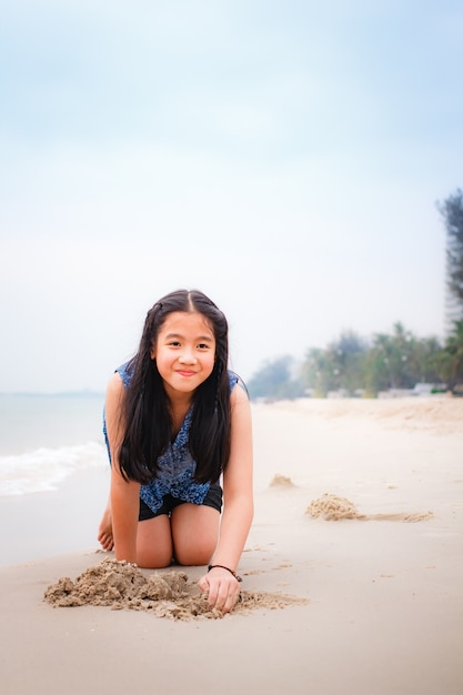 Little girl on the beach in summer day.