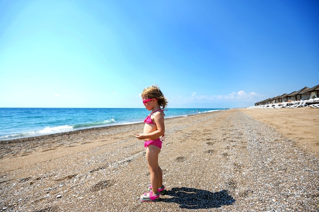 Photo little girl on a beautiful beach at the sea