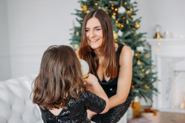 크리스마스 트리의 거실에 유리 공 아름다운 드레스 투투 치마에 어린 소녀