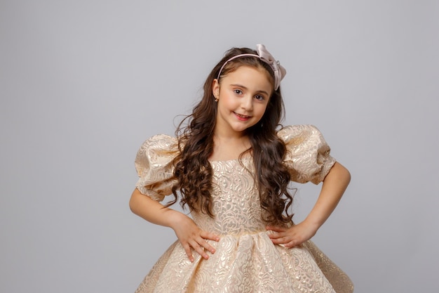 Little girl in a beautiful dress on a white background