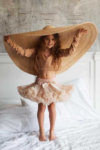 Foto bambina in un grande cappello di paglia
