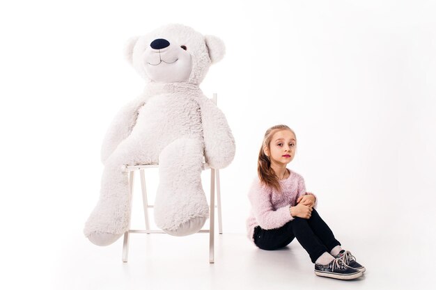 Little girl and a big white teddy bear