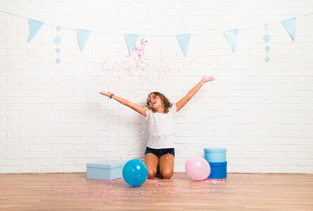 Little girl in a birthday party playing with confetti