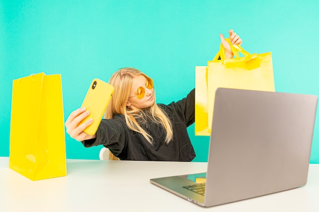 Little girl blogger make online review something with recorded using the smartphone on light blue background.