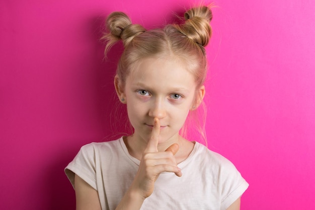 Little girl blonde on a pink background