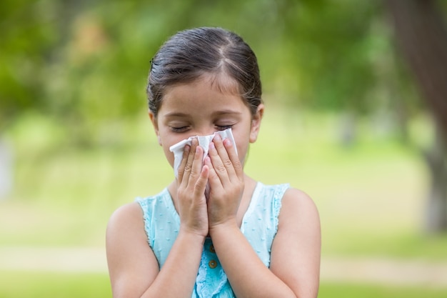 Little girl blowing his nose 