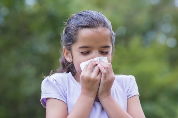 Little girl blowing his nose 