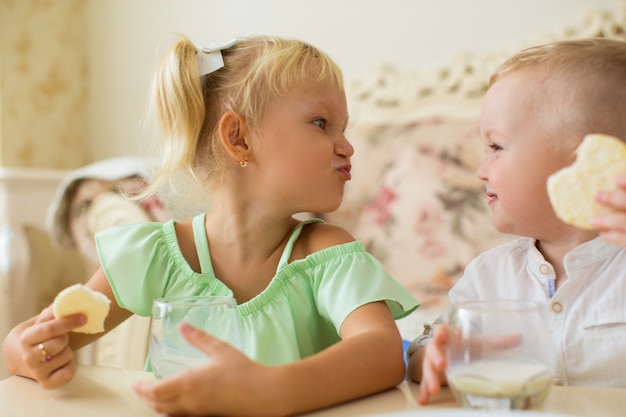 Little Girl and Boy Making Faces at Breakfast