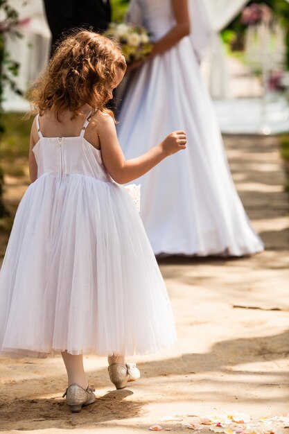 The little girl and brides at the outdoor ceremony