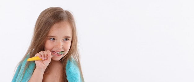 A little girl brushes her teeth