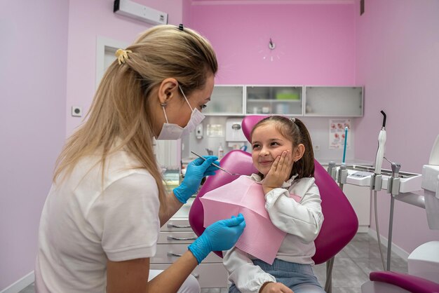 Фото Маленькая девочка пришла к стоматологу с зубной болью на лечение.