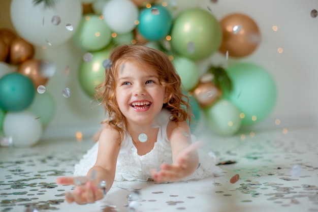 Little girl celebrating birthday catches confetti