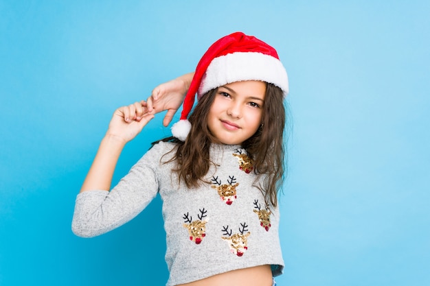 少女が腕を伸ばしてクリスマスの日を祝って、リラックスした位置。