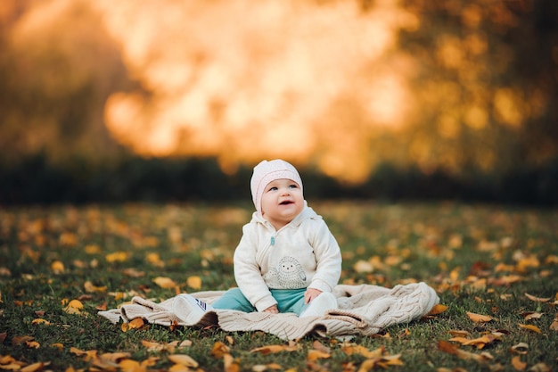 A little girl child in the autumn park smiles spends time beautiful autumn background