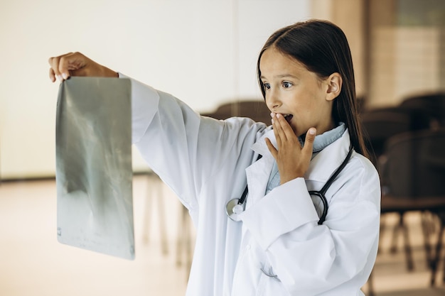 Маленькая девочка-врач смотрит на рентген