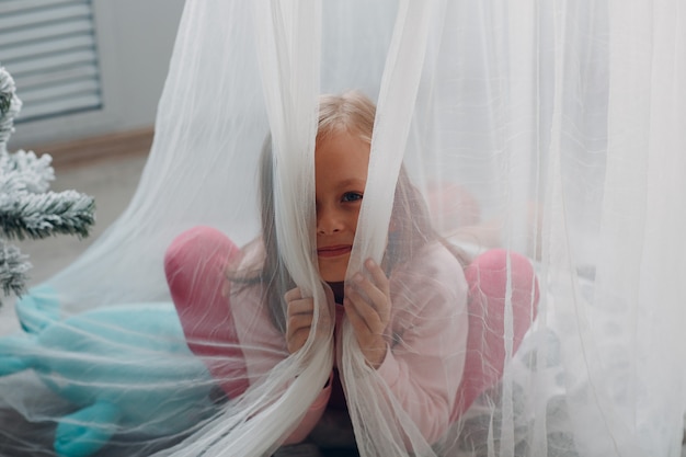 Bambina in abiti rosa ritratto a casa.