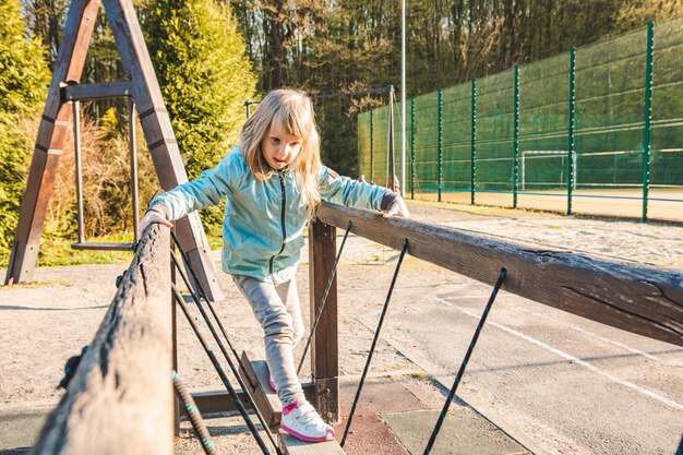 Little girl at children playground copy space