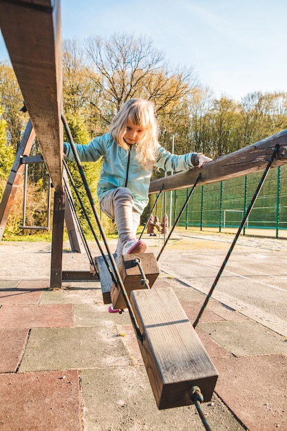 Little girl at children playground copy space