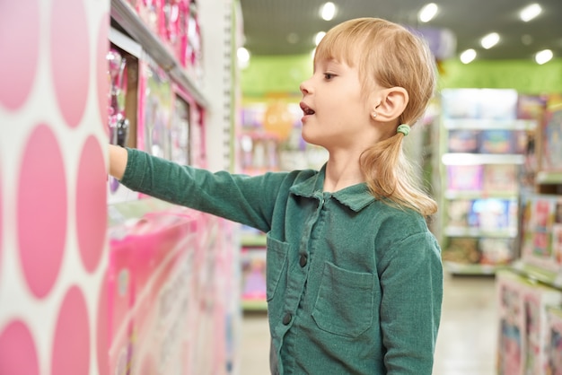 Little girl choosing toy in big shopping centre.