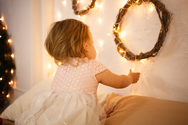 A little girl in a Christmas studio. yellow lights, baby.
