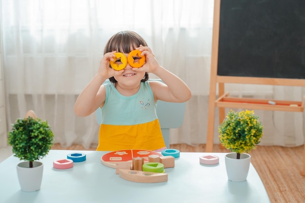 La bambina raccoglie una piramide in legno non verniciata giocattoli sicuri per bambini in legno naturale