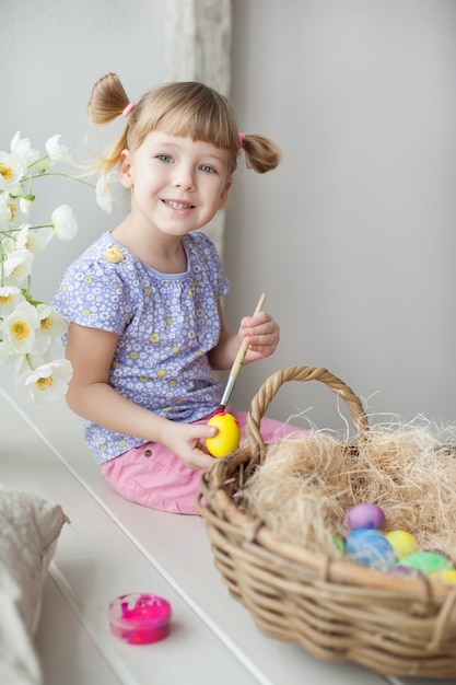 Little girl coloring easter eggs