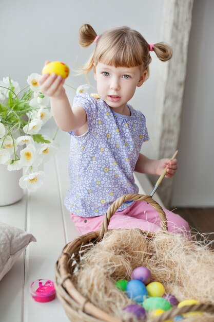 Little girl coloring easter eggs