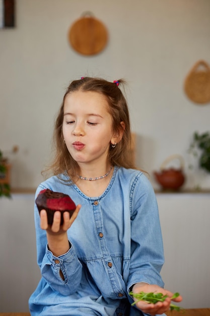 Little girl comparing food choosing sweet cake against microgreen UnHealthy habit