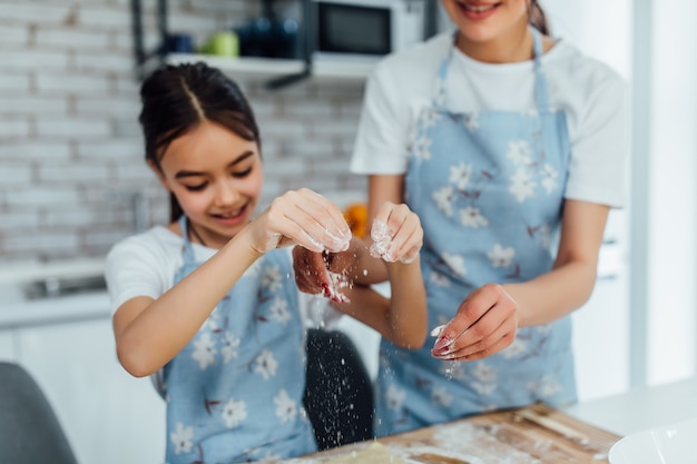 little girl cooking dough on the kitchen