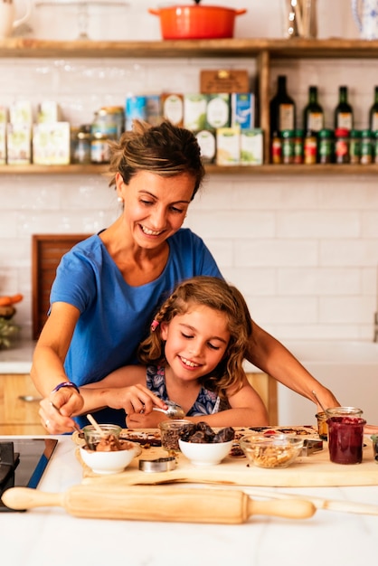 Little girl cooking with her mother in the kitchen. Infant Chef Concept.